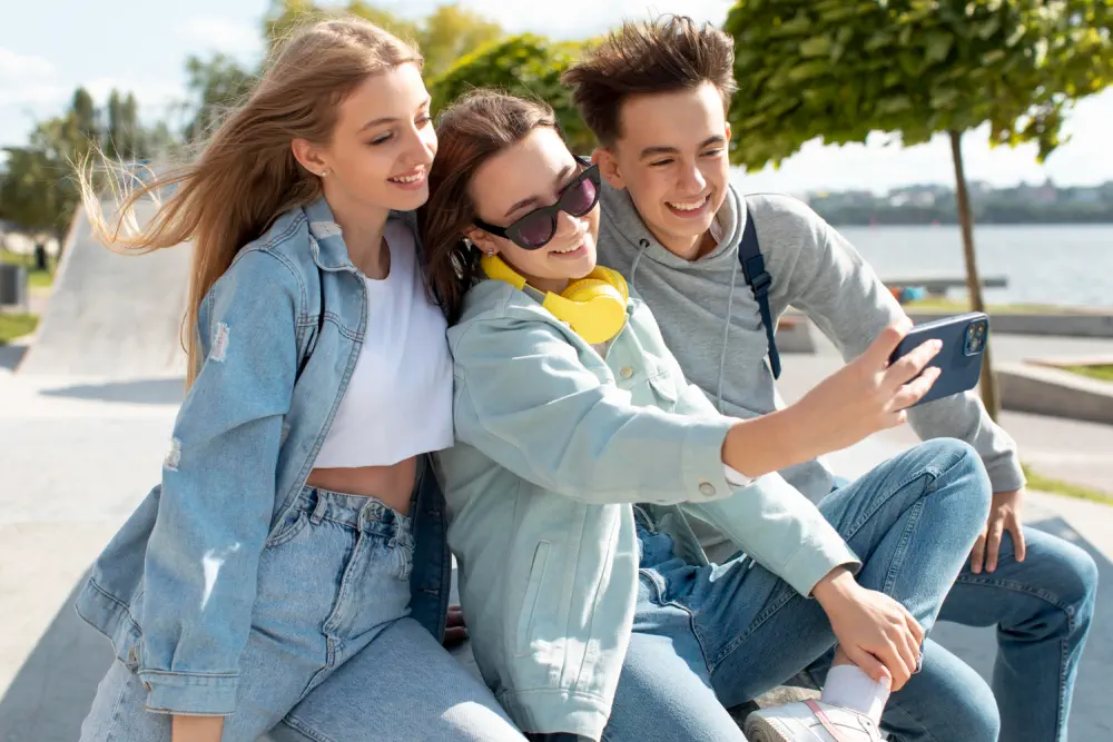 Three smiling teens taking a selfie