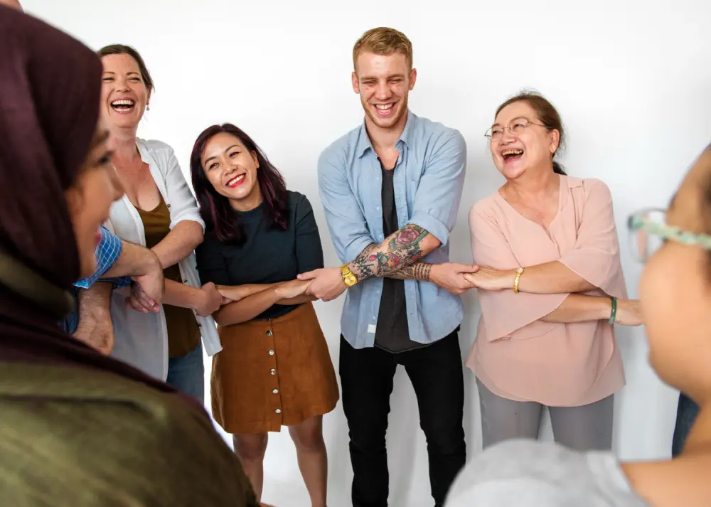 Joyful group holding hands in a circle.