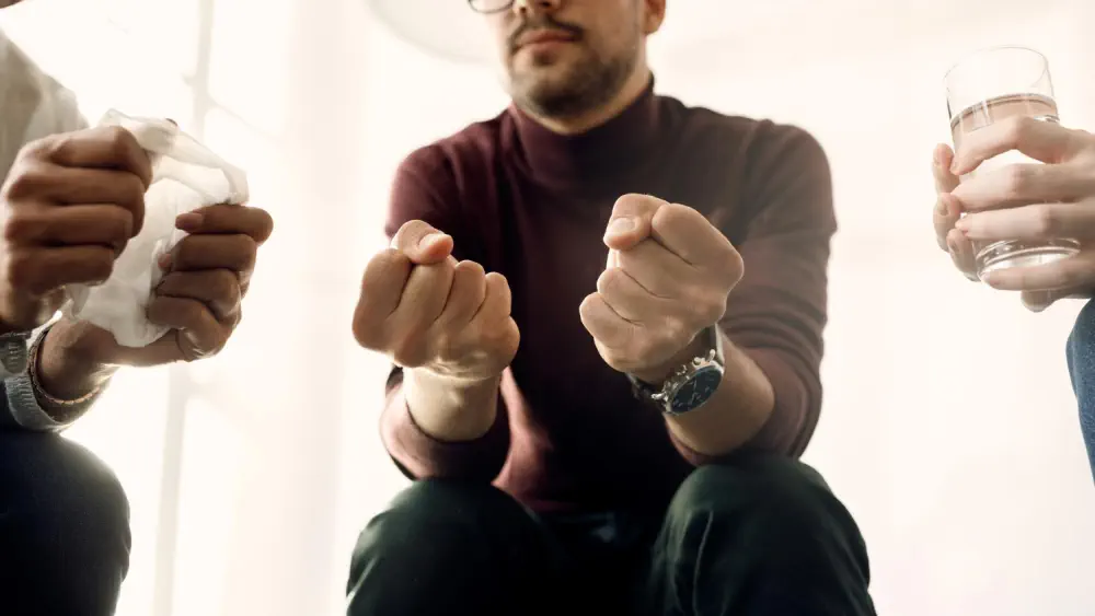 Person clenching hands, representing confusion from thiamine deficiency.