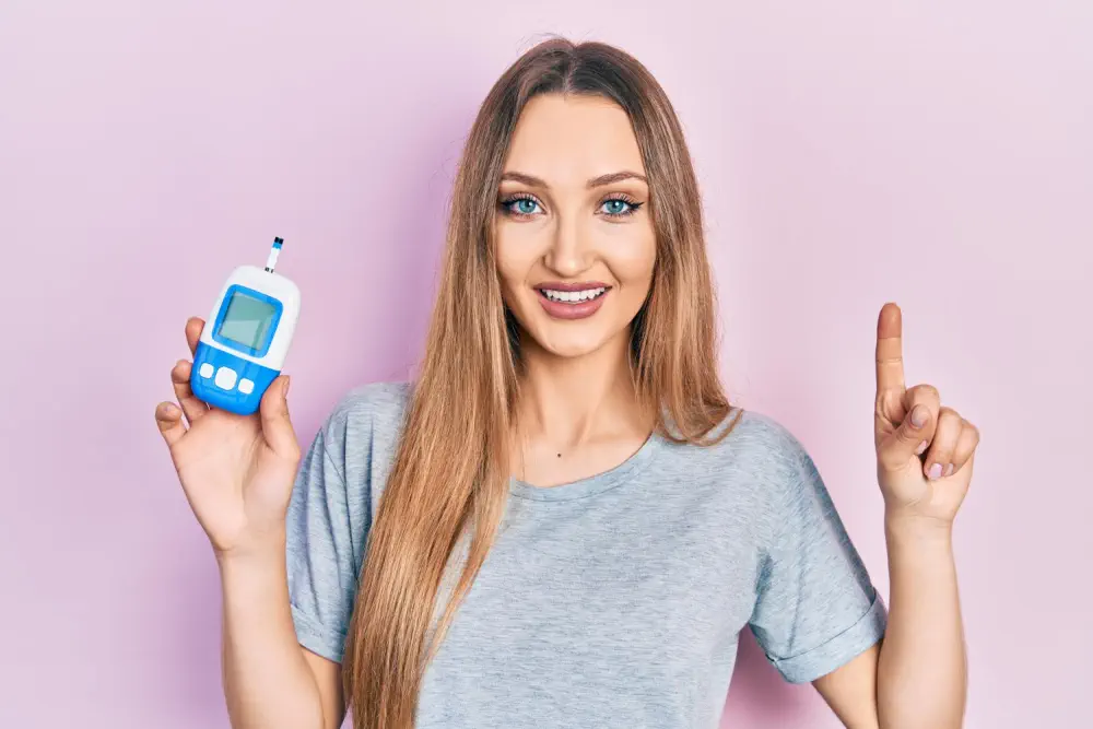 Woman with glucose monitor representing the link between alcohol and blood sugar.