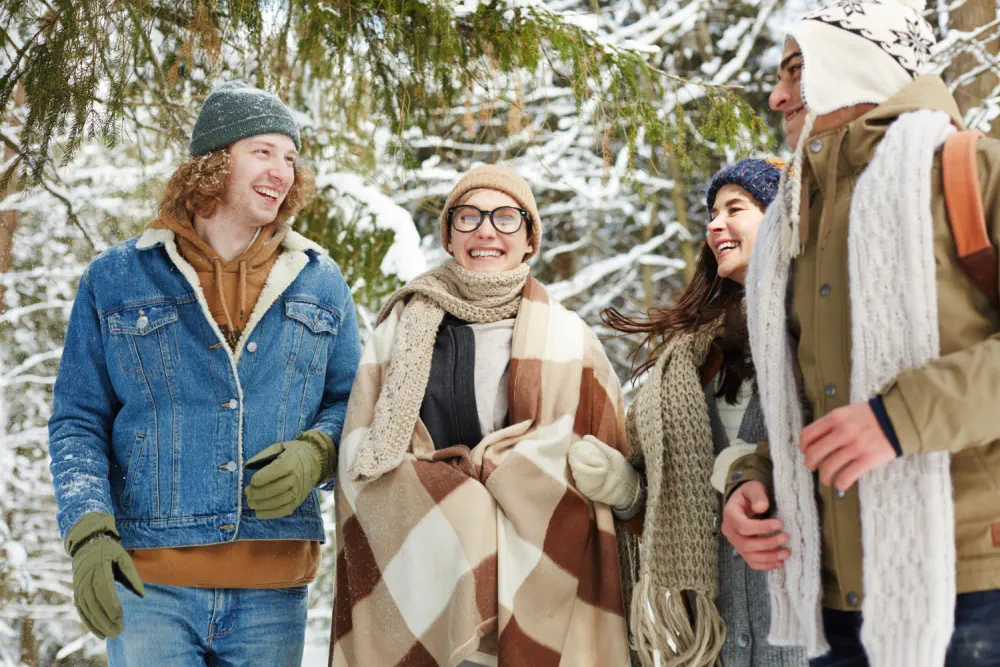 Friends laughing in the snow, unaware of antidepressant and alcohol risks.